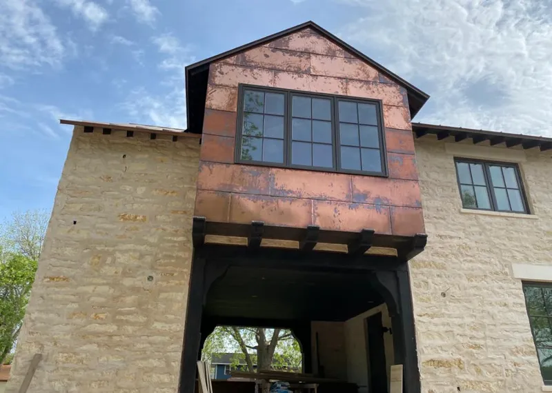 Copper metal panel facade on a stone building for Roof Repair in South Hill